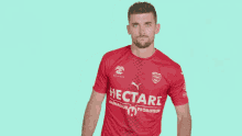 a man in a red shirt that says hecta on it