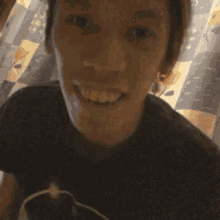 a close up of a man 's face with a black shirt on smiling .