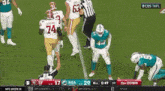 a football game is being played between the san francisco 49ers and the miami dolphins on a television screen .