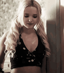 a blonde woman wearing a black crop top and pigtails