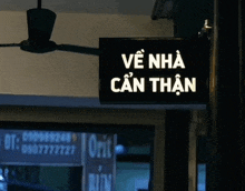 a sign that says về nha can than hangs from a pole