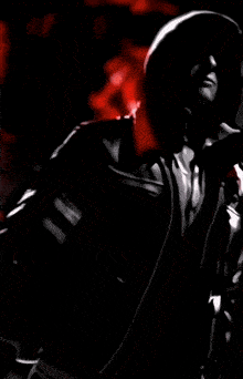 a close up of a person 's face with a red light behind them