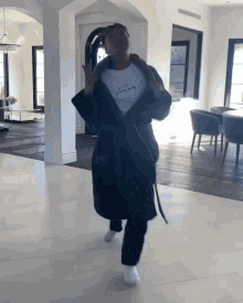 a woman in a bathrobe is wearing a t-shirt that says " love everybody "