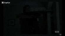 a silhouette of a man holding a gun in the dark .