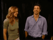 a man and a woman are standing next to each other in a dark room .