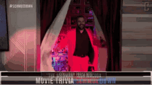 a man in a red suit is walking through a doorway with the words movie trivia on the bottom right