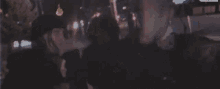 two people are standing next to each other on a street at night and one of them is wearing a helmet