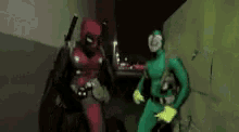 a couple of people in superhero costumes are standing next to each other .