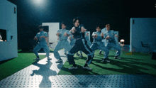 a group of people in overalls are dancing on a stage in a dark room