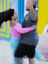 a man is holding a woman in his arms while they are dancing in a room .