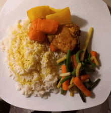 a white plate topped with rice carrots green beans and meat