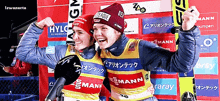 two female skiers are posing for a picture and one has the word hylg on her hat