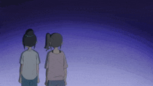 a couple of girls standing next to each other in a dark room