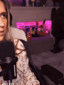 a woman is sitting in a chair with a shure microphone