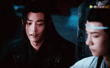 a man with long hair is looking at another man with chinese writing on the bottom