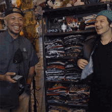 two men are standing in front of a shelf with a clock that says 034