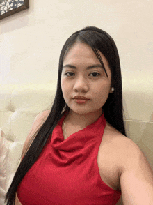 a woman in a red top is sitting on a white couch