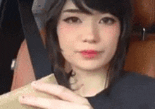 a close up of a woman 's face with a hand on her chin .