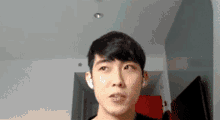 a young man is looking at the camera with a serious look on his face