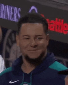 a man with dreadlocks is smiling and wearing a blue sweatshirt
