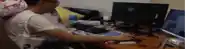 a man is sitting at a desk with a computer monitor and a keyboard .