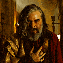 a man with long hair and a beard is wearing a ring on his left hand