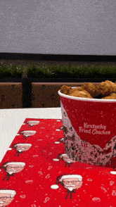 a bucket of kentucky fried chicken is sitting on a table