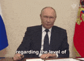 a man in a suit and tie is sitting at a desk with the words regarding the level of in front of him