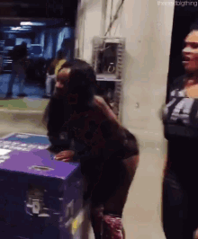 a woman standing next to a purple box that says the next big thing on it
