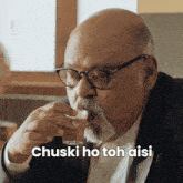 a man with glasses and a beard drinking from a glass with chuski ho toh aisi below him