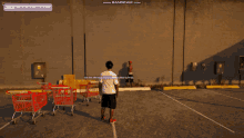 a screenshot of a video game shows a man standing in a parking lot with shopping carts in front of a wall