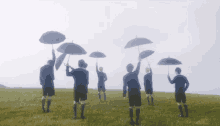 a group of people are holding umbrellas in a field
