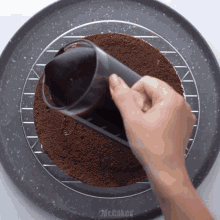 a person is making a chocolate cake with mr.cakes written on the tray