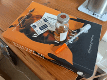 a book by alyson greaves sits on a table next to a syringe