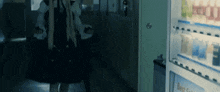 a woman in a black dress is walking past a vending machine that says best seller on it