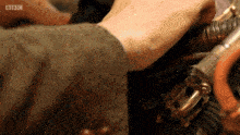 a close up of a person 's hand with the bbc logo on the bottom