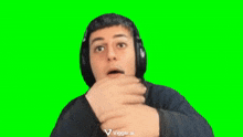 a young man is wearing headphones and making a funny face .