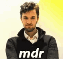 a man with a beard is wearing a black sweater that says mdr on it .