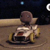 a stuffed animal is driving a cardboard car on a track