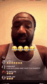 a man with a beard and a white tank top is crying and laughing