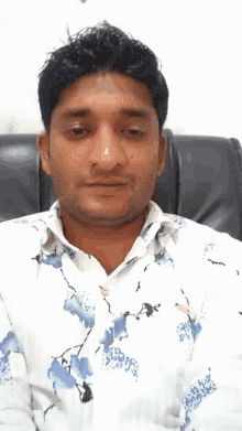 a man in a white shirt with blue flowers on it