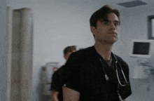 a man with a stethoscope around his neck looks at something