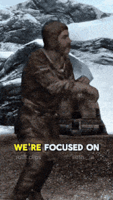 a man is standing in front of a mountain with the words we 're focused on below him