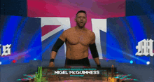 a wrestler named nigel mcguinness is standing in front of a british flag