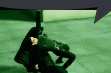 a man is laying on the ground with his arms outstretched in a green room .