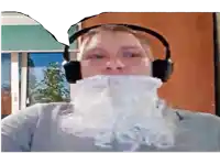 a man wearing headphones has a fake beard covering his mouth