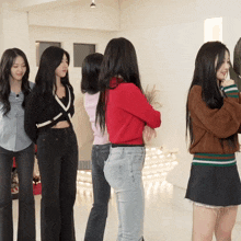 a group of girls are standing in a room with their arms crossed