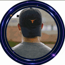 a man wearing a hat with a bull on it is in a purple circle