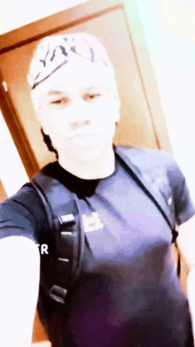 a man taking a selfie with the letter r on his chest
