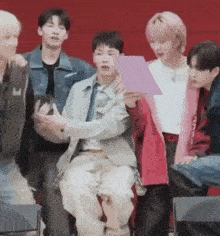 a group of young men are sitting in chairs and talking to each other .